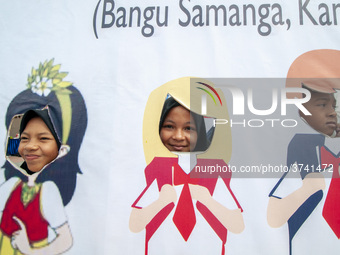 Students take pictures on a vehicle playing in the Back to School Campaign held by the Sayangi Tunas Cilik Foundation (STC) at Vatulemo Fiel...