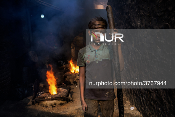 Shihab (8) works in a metal shop near shipyard where he breaks metal small pieces and puts them into the furnace. Dhaka, Bangladesh, Februar...