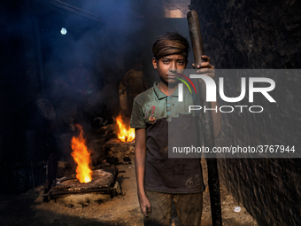 Shihab (8) works in a metal shop near shipyard where he breaks metal small pieces and puts them into the furnace. Dhaka, Bangladesh, Februar...