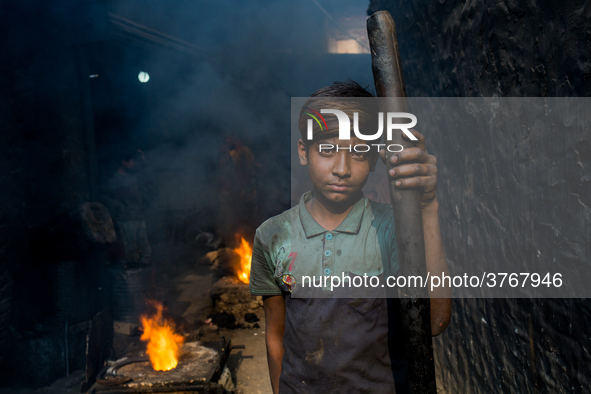 Shihab (8) works in a metal shop near shipyard where he breaks metal small pieces and puts them into the furnace. Dhaka, Bangladesh, Februar...