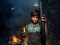 Shihab (8) works in a metal shop near shipyard where he breaks metal small pieces and puts them into the furnace. Dhaka, Bangladesh, Februar...