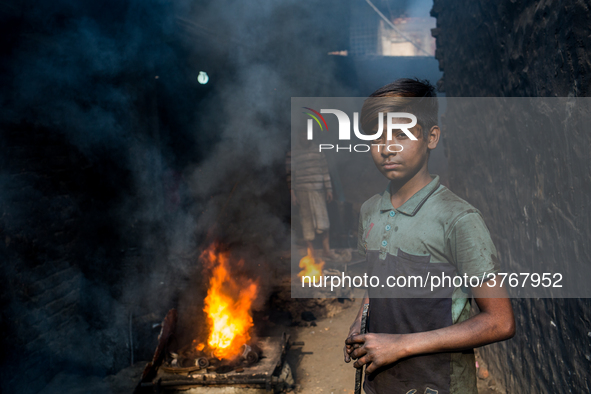 Shihab (8) works in a metal shop near shipyard where he breaks metal small pieces and puts them into the furnace. Dhaka, Bangladesh, Februar...