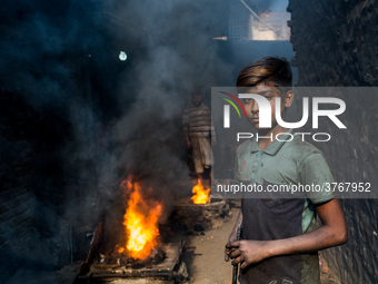 Shihab (8) works in a metal shop near shipyard where he breaks metal small pieces and puts them into the furnace. Dhaka, Bangladesh, Februar...