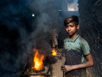 Shihab (8) works in a metal shop near shipyard where he breaks metal small pieces and puts them into the furnace. Dhaka, Bangladesh, Februar...