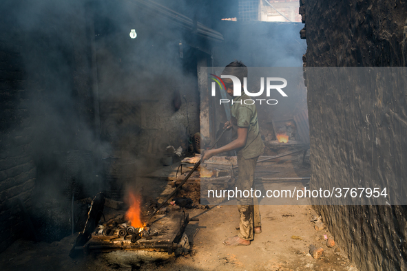 Shihab (8) works in a metal shop near shipyard where he breaks metal small pieces and puts them into the furnace. Dhaka, Bangladesh, Februar...