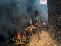 Shihab (8) works in a metal shop near shipyard where he breaks metal small pieces and puts them into the furnace. Dhaka, Bangladesh, Februar...