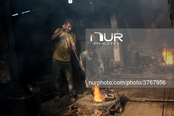 Workers work in a metal shop near shipyard where he breaks metal small pieces and puts them into the furnace. Dhaka, Bangladesh, February 7,...