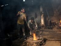 Workers work in a metal shop near shipyard where he breaks metal small pieces and puts them into the furnace. Dhaka, Bangladesh, February 7,...