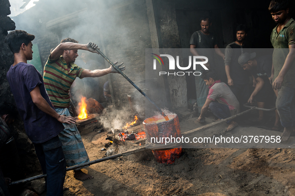 Workers work in a metal shop near shipyard where he breaks metal small pieces and puts them into the furnace. Dhaka, Bangladesh, February 7,...