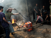 Workers work in a metal shop near shipyard where he breaks metal small pieces and puts them into the furnace. Dhaka, Bangladesh, February 7,...