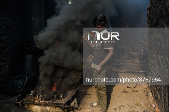 A child worker works in a metal shop near shipyard where he breaks metal small pieces and puts them into the furnace. Dhaka, Bangladesh, Feb...