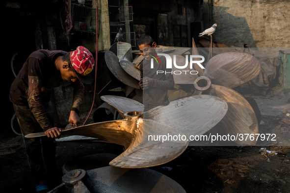 A child worker laughs with his supervisor in a metal workshop near Dhaka Shipyard, Bangladesh, February 7, 2019 