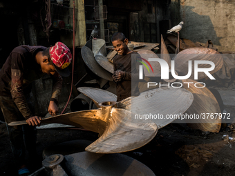 A child worker laughs with his supervisor in a metal workshop near Dhaka Shipyard, Bangladesh, February 7, 2019 (