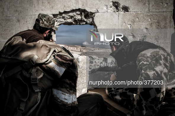 A group of rebels who monitor sites the regime forces during shelling it by mortars and hell cannon, in Aleppo,on December 17, 2014.  