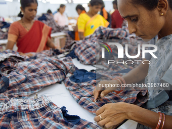 A seamstress removing threads from clothing destined for the US market at a garment factory in Bangalore. Many of the workers emigrate from...