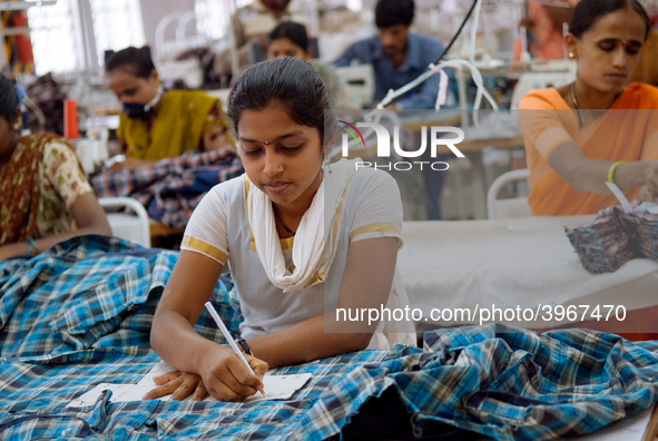 Workers making clothing at a garment factory in Bangalore. Many of the workers emigrate from poor regions of the country, making clothes to...