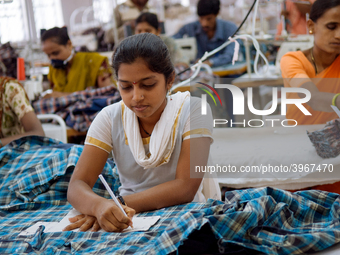 Workers making clothing at a garment factory in Bangalore. Many of the workers emigrate from poor regions of the country, making clothes to...