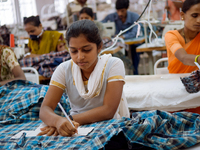 Workers making clothing at a garment factory in Bangalore. Many of the workers emigrate from poor regions of the country, making clothes to...