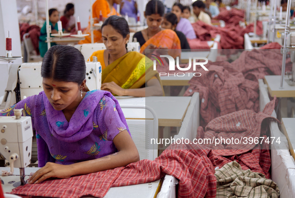 Textile workers making clothing in Bangalore. Many of the workers emigrate from poor regions of the country, making clothes to be sold in th...