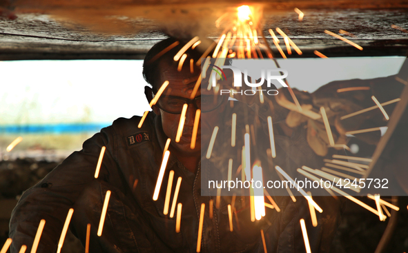 
quid iron is flowing into the prepared propeller mould at a dockyard on the bank of River Buriganga in Dhaka, Bangladesh 