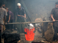 Liquid iron is flowing into the prepared propeller mould at a dockyard on the bank of River Buriganga in Dhaka, Bangladesh (