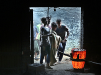 Liquid iron is flowing into the prepared propeller mould at a dockyard on the bank of River Buriganga in Dhaka, Bangladesh (