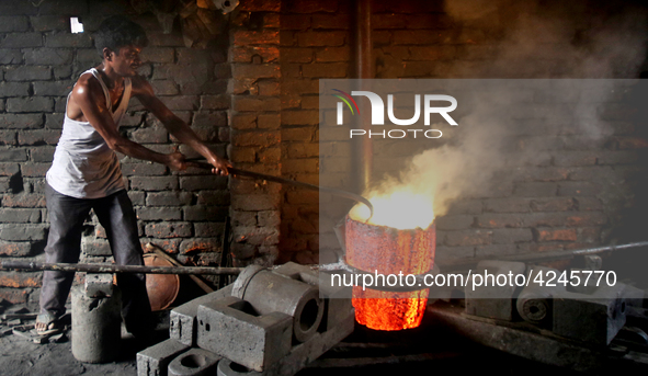 Liquid iron is flowing into the prepared propeller mould at a dockyard on the bank of River Buriganga in Dhaka, Bangladesh 