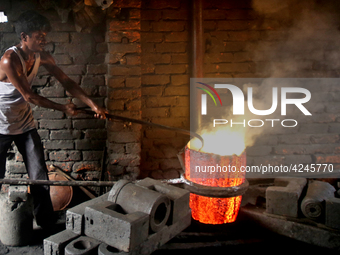 Liquid iron is flowing into the prepared propeller mould at a dockyard on the bank of River Buriganga in Dhaka, Bangladesh (