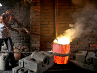 Liquid iron is flowing into the prepared propeller mould at a dockyard on the bank of River Buriganga in Dhaka, Bangladesh (