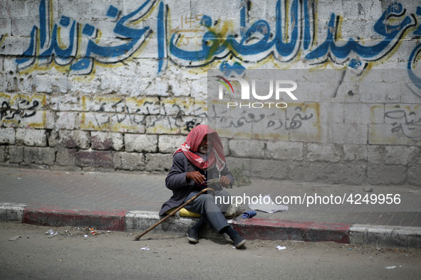 A Palestinian man sits on a sidewalk, in Gaza City  May 1, 2019.
 