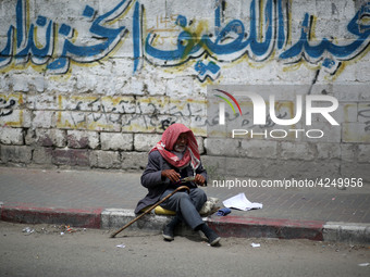 A Palestinian man sits on a sidewalk, in Gaza City  May 1, 2019.
 (