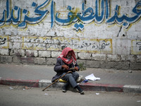 A Palestinian man sits on a sidewalk, in Gaza City  May 1, 2019.
 (