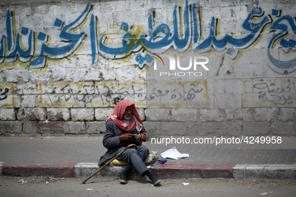 A Palestinian man sits on a sidewalk, in Gaza City  May 1, 2019.
 