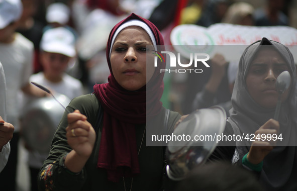 Palestinians  bang on pots during a rally marking International Workers' Day, or Labour Day, in Gaza City May 1, 2019. 
 