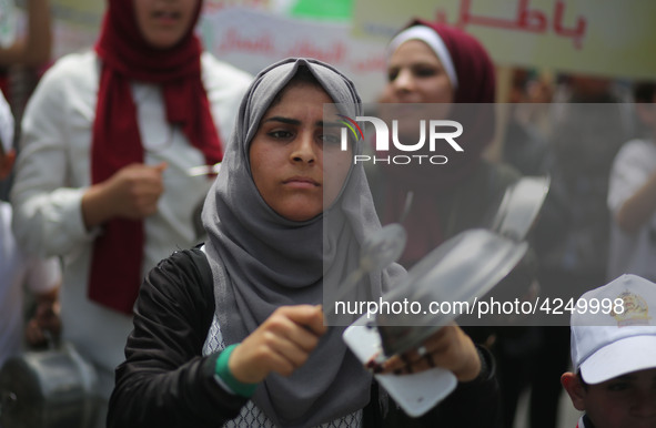 Palestinians  bang on pots during a rally marking International Workers' Day, or Labour Day, in Gaza City May 1, 2019. 
 