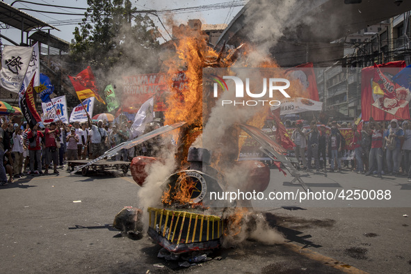 Protesters burn an effigy of Philippine President Rodrigo Duterte during Labor Day demonstrations outside the presidential palace on May 1,...