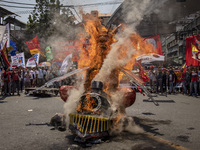 Protesters burn an effigy of Philippine President Rodrigo Duterte during Labor Day demonstrations outside the presidential palace on May 1,...