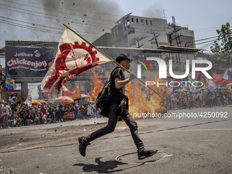 Protesters burn an effigy of Philippine President Rodrigo Duterte during Labor Day demonstrations outside the presidential palace on May 1,...