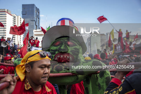 Jakarta, 01 May 2019 : Puppet with USA Flag represent capitalism were lifted up during the dance ceremony at the demonstration location. Tho...