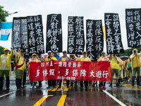 Protesters posing with banners and flags calling for more holidays, paid leave, more labour rights protections. During 2019 Labor Day March...