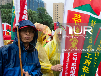 A Protester posing with a flag  between banners calling for more holidays, paid leave, more labour rights protections. During 2019 Labor Day...