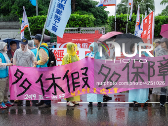 Protesters posing with banners and flags calling for more holidays, paid leave, more labour rights protections. During 2019 Labor Day March...