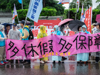 Protesters posing with banners and flags calling for more holidays, paid leave, more labour rights protections. During 2019 Labor Day March...