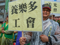 A Protester marching with a banner calling for more holidays, paid leave, more labour rights protections. During 2019 Labor Day March 6,000...