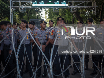 Police guard behind a barbed wire in a May Day rally in Jakarta on May 1, 2019.  Thousands of Indonesian workers are urging the government t...