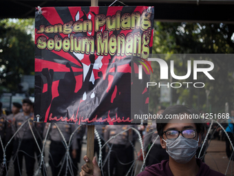 Indonesian worker holds placard during May Day rally in Jakarta on May 1, 2019.  Thousands of Indonesian workers are urging the government t...