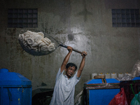 A man carries a basket full with kerupuk or crackers after frying them at a kerupuk factory in Depok, Indonesia, 01 May, 2019. Despite the g...