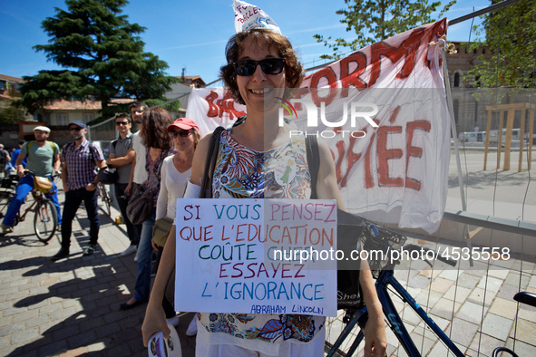 A teacher holds a placrad reading 'If you are thinking that education costs too much, try ignirance !'. Some high school teachers were on st...