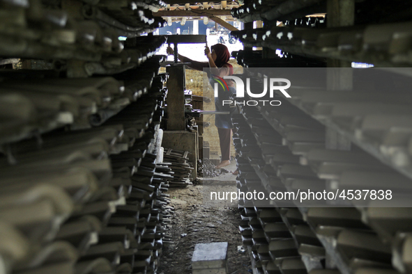 Female workers work on making tiles in clay tile factories at Pakuncen sub-district, Banyumas regency, Central Java province, on June 16, 20...