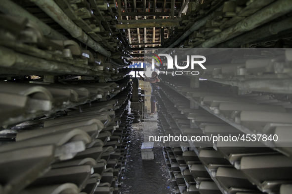 Female workers work on making tiles in clay tile factories at Pakuncen sub-district, Banyumas regency, Central Java province, on June 16, 20...